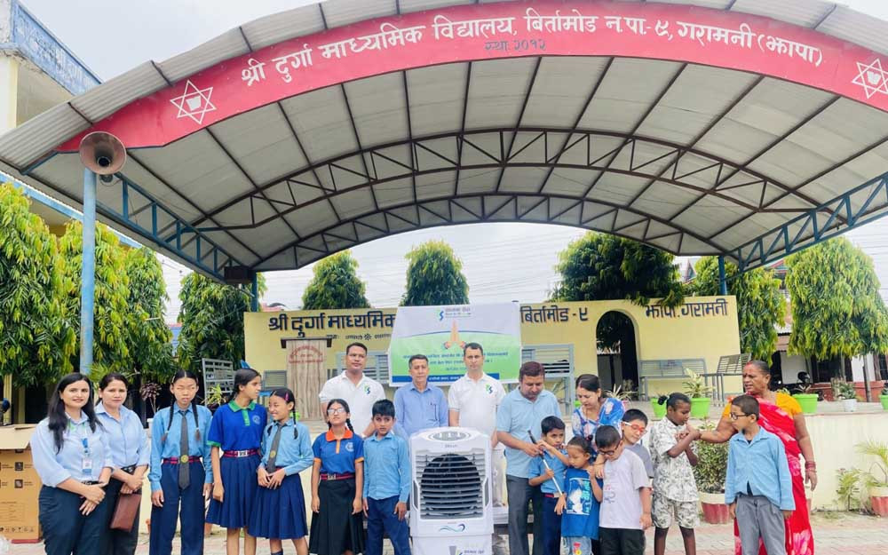 कामना सेवा विकास बैकले दियो बिर्तामोडको विद्यालयलाई कुलर र ब्रेल पेपर